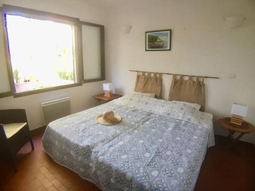 1 dormitorio con 1 cama con sombrero en Maison Porto-Vecchio, 3 pièces, 6 personnes - FR-1-62-152 en Porto Vecchio