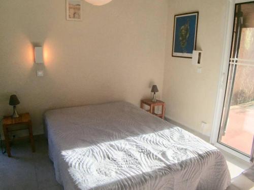 een slaapkamer met een bed en een groot raam bij Maison Porto-Vecchio, 1 pièce, 2 personnes - FR-1-62-159 in Porto-Vecchio