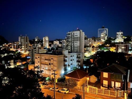 een skyline van de stad 's nachts met gebouwen en auto's bij Apartamento em Bento Gonçalves in Bento Gonçalves