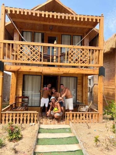a group of people standing in front of a house at Green Beach Camp & Hotel in Nuweiba