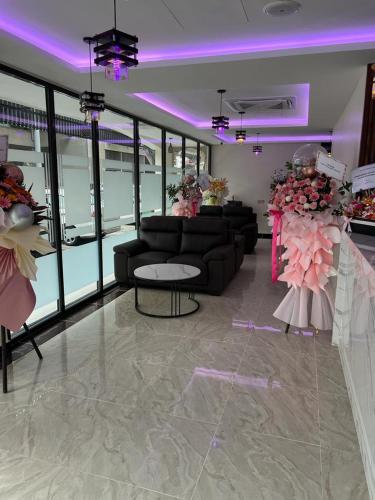a living room with black couches and pink lighting at One Dream Hotel in Petaling Jaya