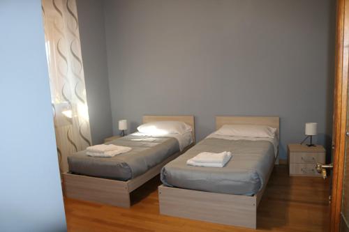 2 camas en una habitación con puerta abierta en Sant'Anna, en Saluzzo