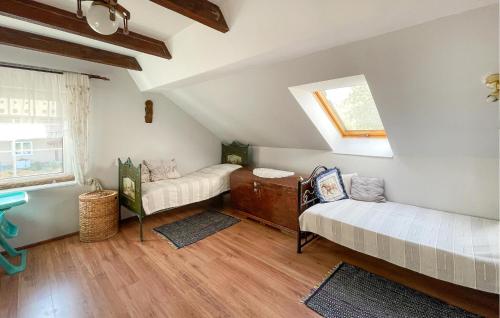 a attic room with two beds and a window at 4 Bedroom Cozy Home In Lidzbark Warminski in Lidzbark Warmiński