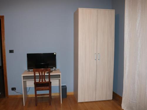 a desk with a computer and a cabinet in a room at Sant'Anna in Saluzzo