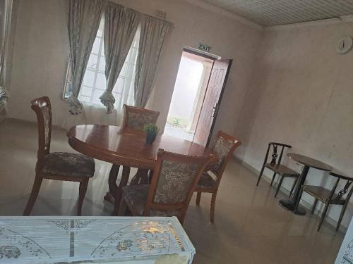 a dining room with a wooden table and chairs at Virgin guesthouse in Francistown