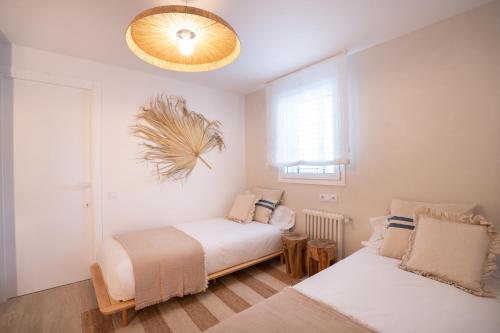 um quarto com 2 camas e um lustre em Casa de vacaciones en La Ràpita em Sant Carles de la Ràpita