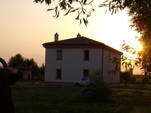 a white house with a car parked in front of it at Antico Casale dei Sogni agriturismo in Lugo