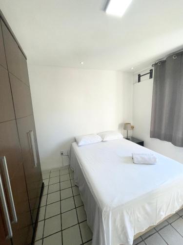 um quarto com uma grande cama branca num quarto em APARTAMENTO NO MELHOR DE BOA VIAGEM no Recife