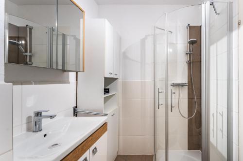 a bathroom with a sink and a shower at Billys Apartment Zentrum, Renoviert, Garage, Netflix in Mondsee