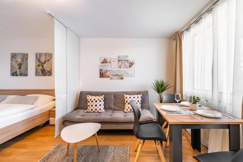 een klein appartement met een bank en een tafel en stoelen bij Billys Apartment Zentrum, Renoviert, Garage, Netflix in Mondsee