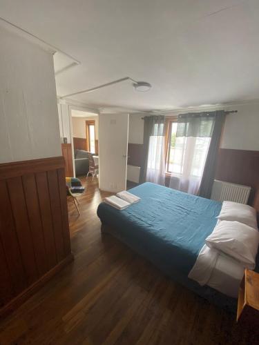 a bedroom with a bed with a blue comforter at Hostal Ochen in Punta Arenas