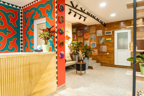 a lobby with a colorful wall with plants at People Hostel & Coworking in Bishkek