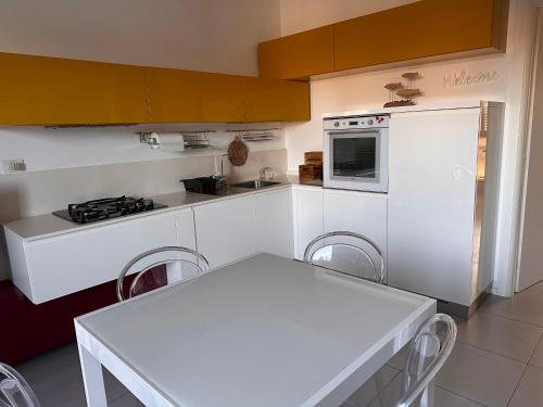 uma cozinha branca com uma mesa branca e um fogão em Casa di Sveva em Marotta