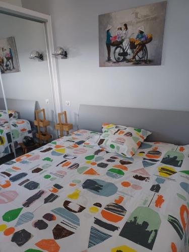 une chambre avec un lit avec une couette colorée dans l'établissement APPARTEMENT T3 vue RHUNE, à Saint-Jean-de-Luz