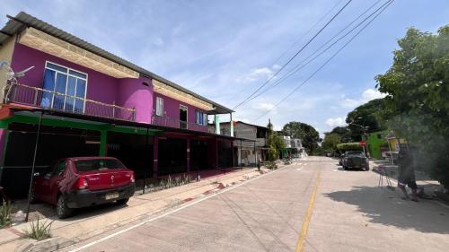 a street with a purple building and a car parked on the street at Apartaestudio en los llanos in Monterrey