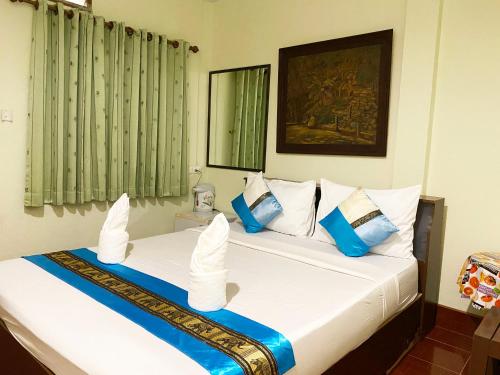 sypialnia z 2 łóżkami i białymi i niebieskimi poduszkami w obiekcie Khaolak Grand City w mieście Khao Lak