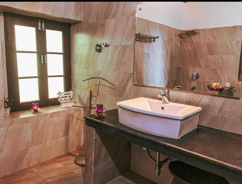 a bathroom with a sink and a large mirror at Cottage Villa Dalhousie in Dalhousie