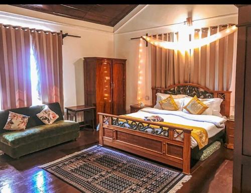a bedroom with a large bed and a couch at Cottage Villa Dalhousie in Dalhousie