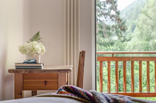 a bedroom with a bed and a table with flowers on it at Hotel Bella di Bosco in Malè