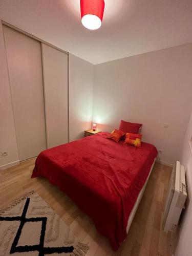 - une chambre avec un lit rouge et une couverture rouge dans l'établissement Appart T3 centre ville Castres, à Castres
