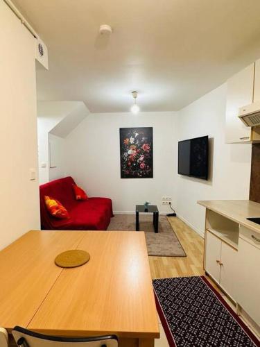 un salon avec une table et un canapé rouge dans l'établissement Appart T3 centre ville Castres, à Castres