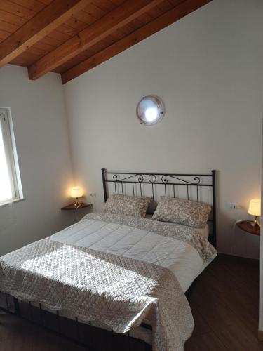 1 dormitorio con 1 cama con sábanas y almohadas blancas en CASCINA LEGNAGO trilocale a 6 chilometri da SALO', en Villanuova sul clisi