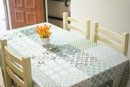 a table with a blue and white table cloth and a vase with flowers at Near Center Apartments 3 in Tirana