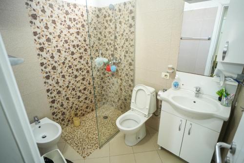 y baño con ducha, aseo y lavamanos. en Grandpa House - App.3, en Tirana