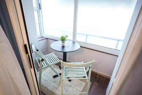 a table and two chairs in a room with a window at Near Center Apartments 3 in Tirana