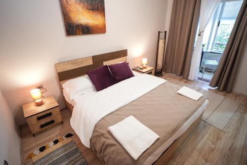 um quarto com uma cama grande e almofadas roxas em Grandpa House - App.3 em Tirana