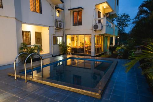 a house with a swimming pool in front of a house at Hangout Villas in Lonavala