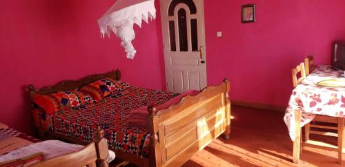 um quarto com 2 camas e uma parede rosa em Antsaly em Antananarivo