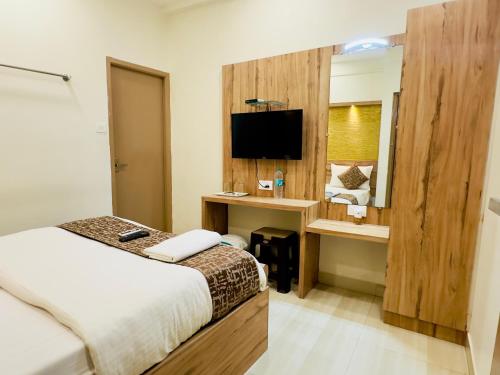 a hotel room with a bed and a desk and a television at Stay Court - Business Class Hotel - Near Central Railway Station in Chennai