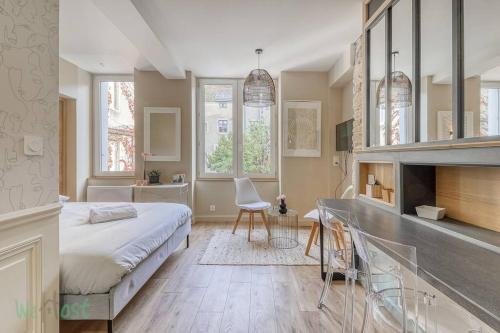 een slaapkamer met een bed en een bureau met een stoel bij Comfortable fully equipped studio - City Center in Dijon