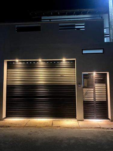 un edificio con dos puertas de garaje con luces. en Minuki guest house, en Weligama