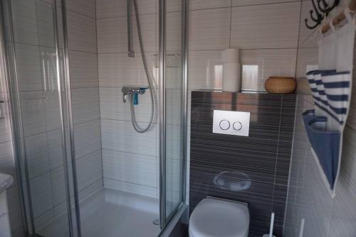uma casa de banho com um chuveiro e um WC. em Apartament nad morzem BALTICA em Jastarnia