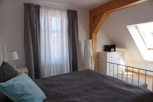 um quarto com uma cama e uma janela em Apartament nad morzem BALTICA em Jastarnia