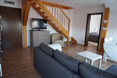 a living room with a couch and a staircase at Apartament nad morzem BALTICA in Jastarnia