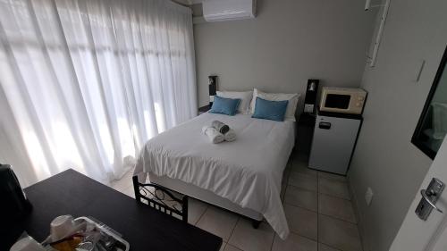 a bedroom with a large bed with blue pillows at Chrisserus Guest Rooms in Bloemfontein