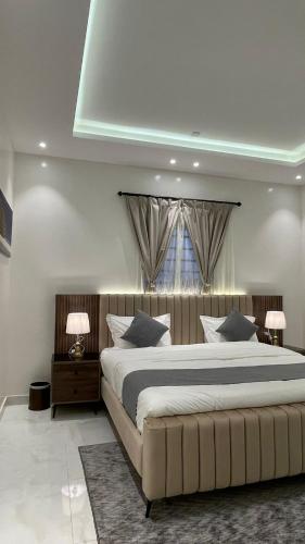 a bedroom with a large bed and a window at شقق ثمانين بارك 2 in Khamis Mushayt