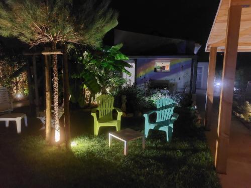 a group of green benches in a yard at night at Gîte, Jacuzzi/Sauna à Colmar in Logelbach