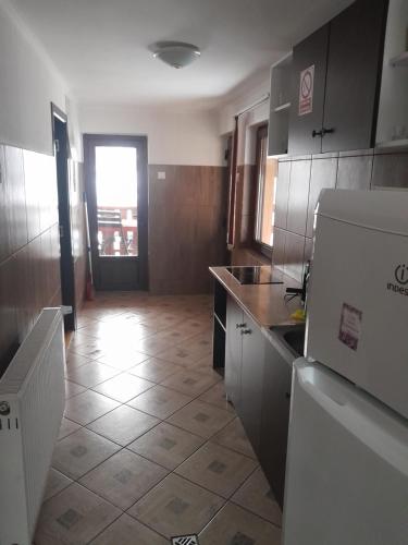 a kitchen with a refrigerator and a tile floor at Apartamente Ambrus E Studio 21 Praid in Praid
