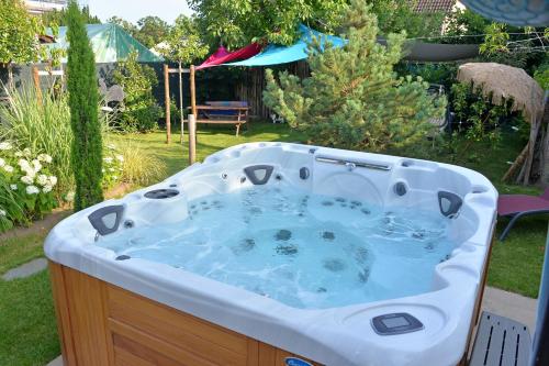 a jacuzzi tub in a yard with an umbrella at Gîte, Jacuzzi/Sauna à Colmar in Logelbach