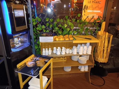 Hôtel Le Phare في اويسترهام: طاولة عليها رف عليه أطباق وخبز