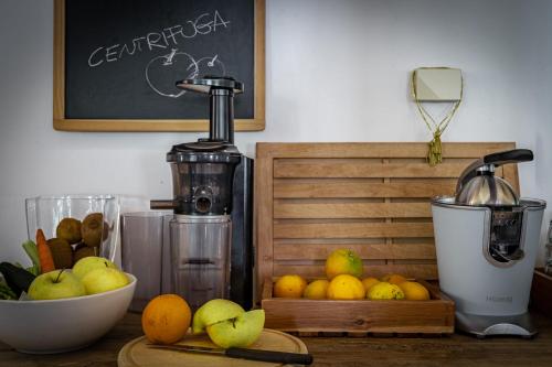 a counter with a juicer and a bowl of fruit at Hotel Bella di Bosco in Malè