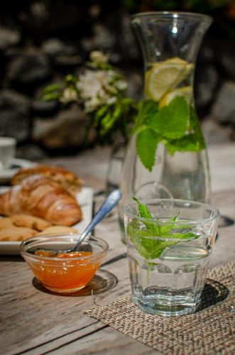 a wooden table with a glass of water and a plate of food at Hotel Bella di Bosco in Malè