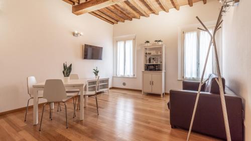a dining room with a table and a couch at [Piazza Martiri]-In pieno centro sotto al Castello in Carpi