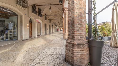 an empty hallway of a building with a brick column at [Piazza Martiri]-In pieno centro sotto al Castello in Carpi