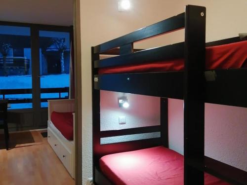 a couple of bunk beds in a room with a window at Studio La Plagne Montalbert , 1 pièce, 5 personnes - FR-1-181-2468 in Aime-La Plagne