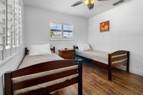 1 dormitorio con 2 camas y ventilador de techo en Florida Life on the Water. Heated Pool, fishing, kayaks, gameroom en Palm Harbor